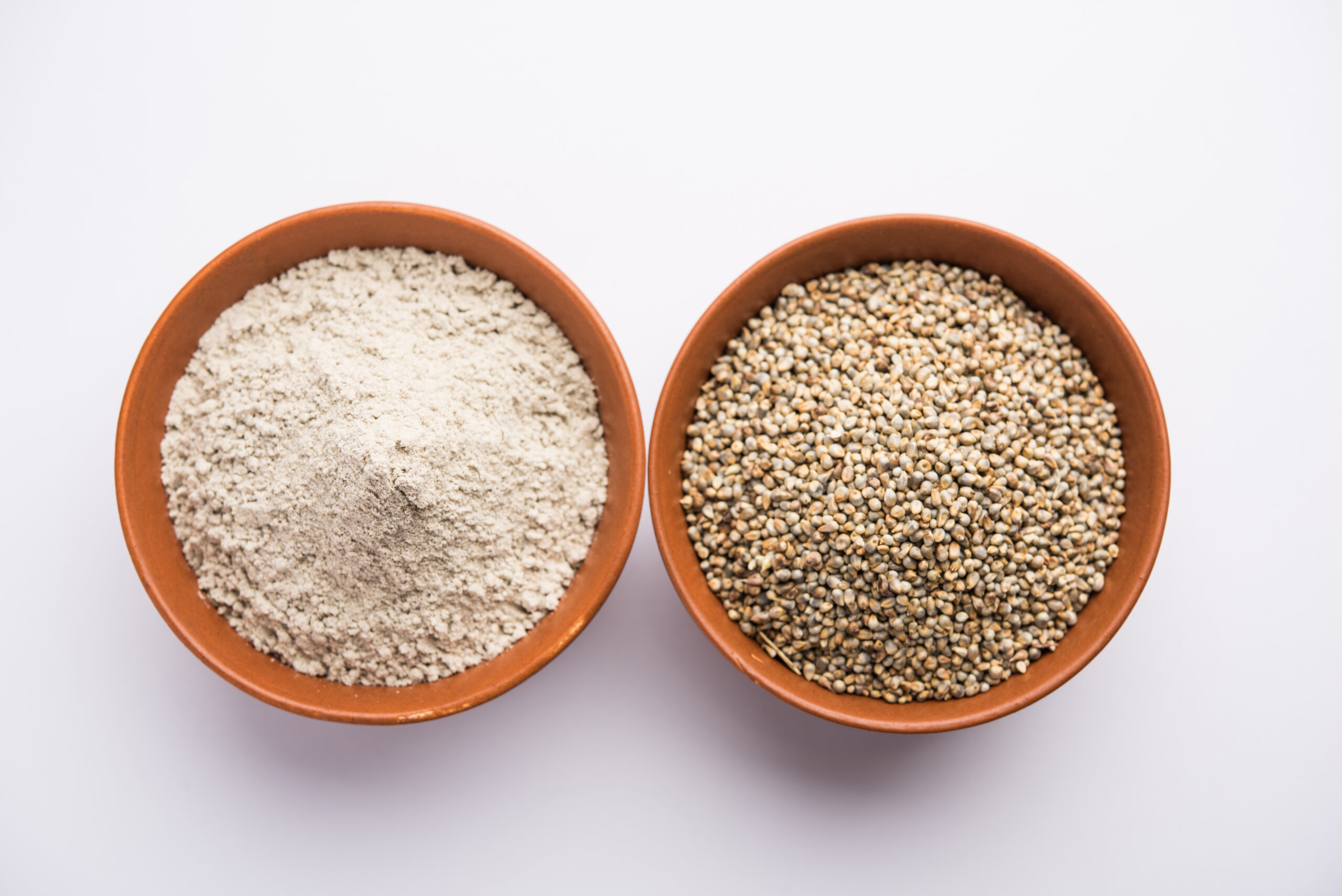 Bajra, pearl millet or sorghum grains with it's flour or powder in a bowl, selective focus