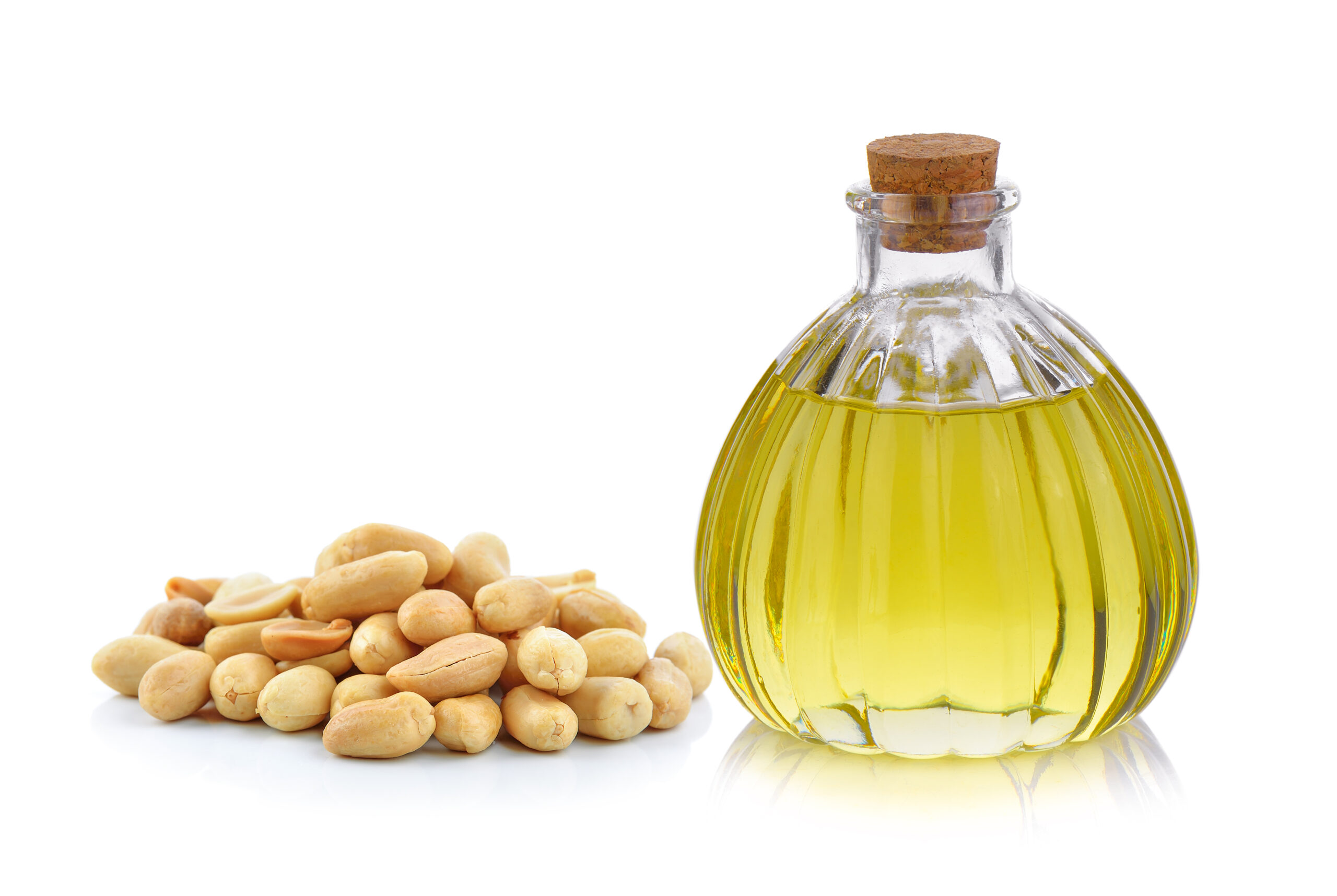 Oil bottle and peanuts on white background